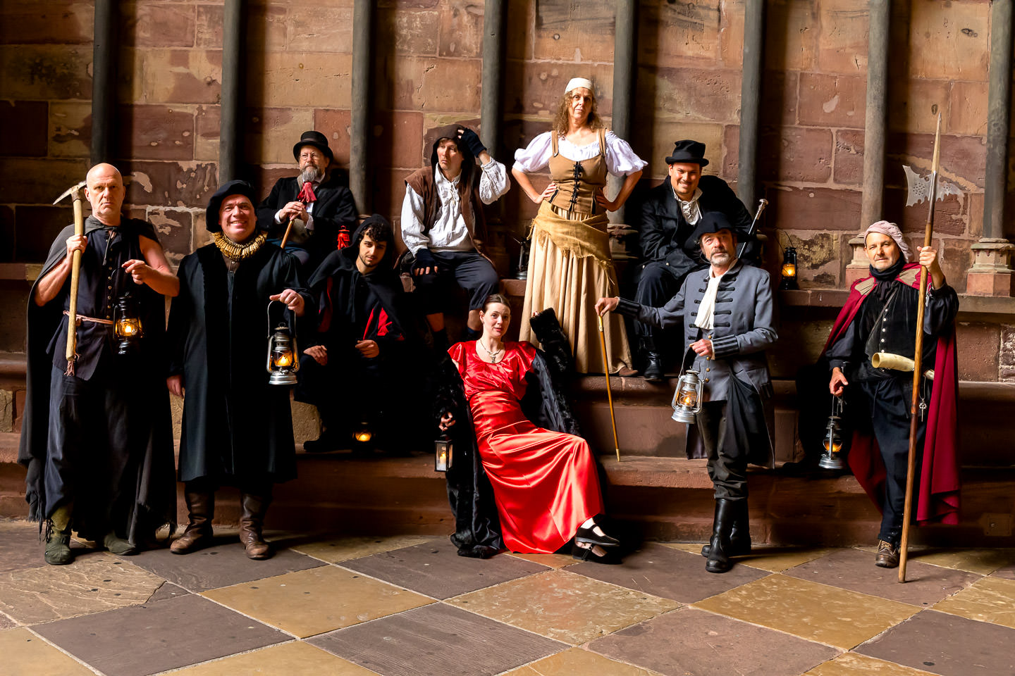 Das Team von Historix-Tours als Gruppe verkleideter Schauspieler in historischen Kostümen für Erlebnistouren und Stadtführungen in der gotischen Münstervorhalle in Freiburg.
